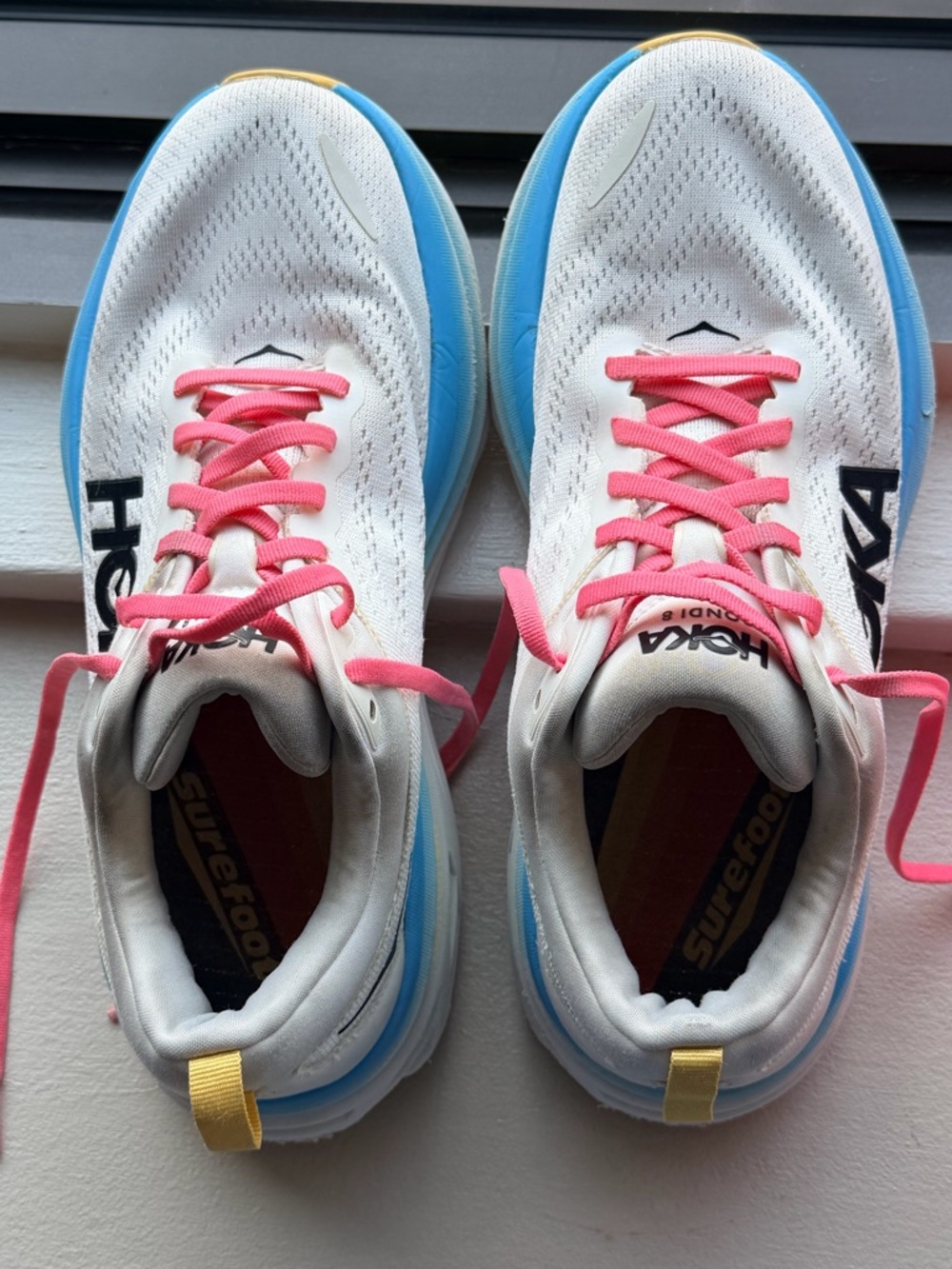 Hoka White Running Shoes with Blue Midsoles and Pink Laces